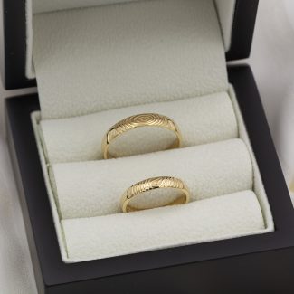 Alianzas personalizadas de oro de primera ley con la huella dactilar de los novios en relieve.