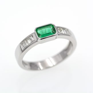 Anillo de oro blanco con esmeralda verde vivo y diamantes.