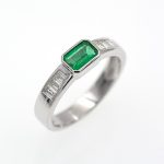 Anillo de oro blanco con esmeralda verde vivo y diamantes.