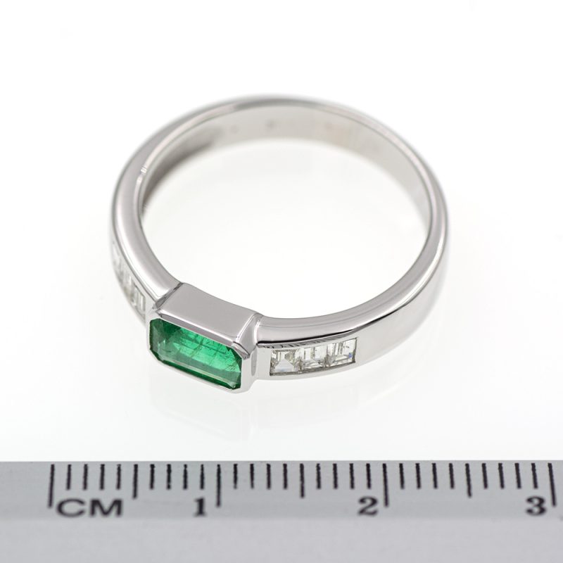 Anillo de oro blanco con esmeralda verde vivo y diamantes.