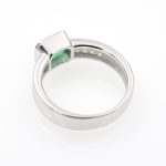 Anillo de oro blanco con esmeralda engastada a bisel y diamantes talla baguette.