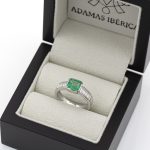 Anillo de oro blanco con esmeralda engastada a bisel y diamantes talla baguette.