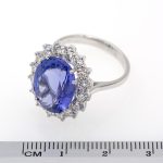 Anillo de oro blanco de primera ley con tanzanita natural rodeada de diamantes.