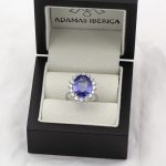 Anillo de oro blanco de primera ley con tanzanita natural rodeada de diamantes.