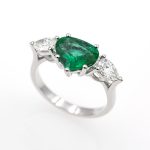 Anillo exclusivo de oro blanco de 18 quilates con una esmeralda y dos diamantes.