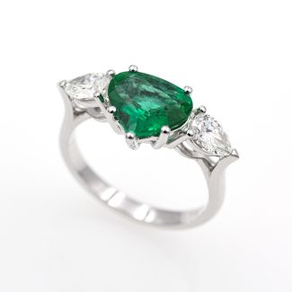 Anillo exclusivo de oro blanco de 18 quilates con una esmeralda y dos diamantes.
