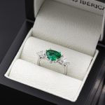 Anillo exclusivo de oro blanco de 18 quilates con una esmeralda y dos diamantes.