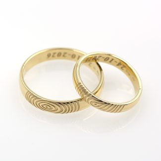Aliaanzas de oro amarillo de primera ley con la huella dactilar de los novios.