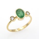 Sortija con esmeralda natural engastada a bisel y diamantes naturales.