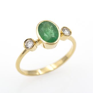Sortija con esmeralda natural engastada a bisel y diamantes naturales.