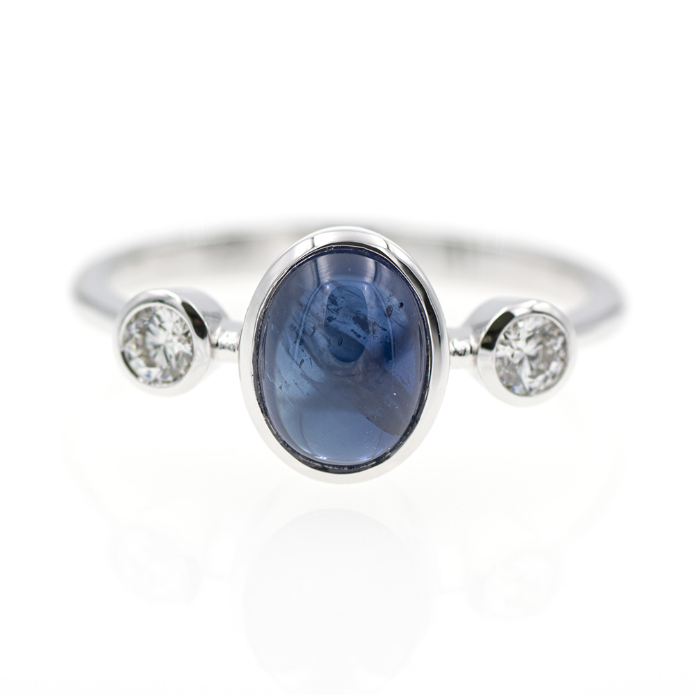 Anillo tresillo de oro blanco 750 con zafiro azul y diamantes.
