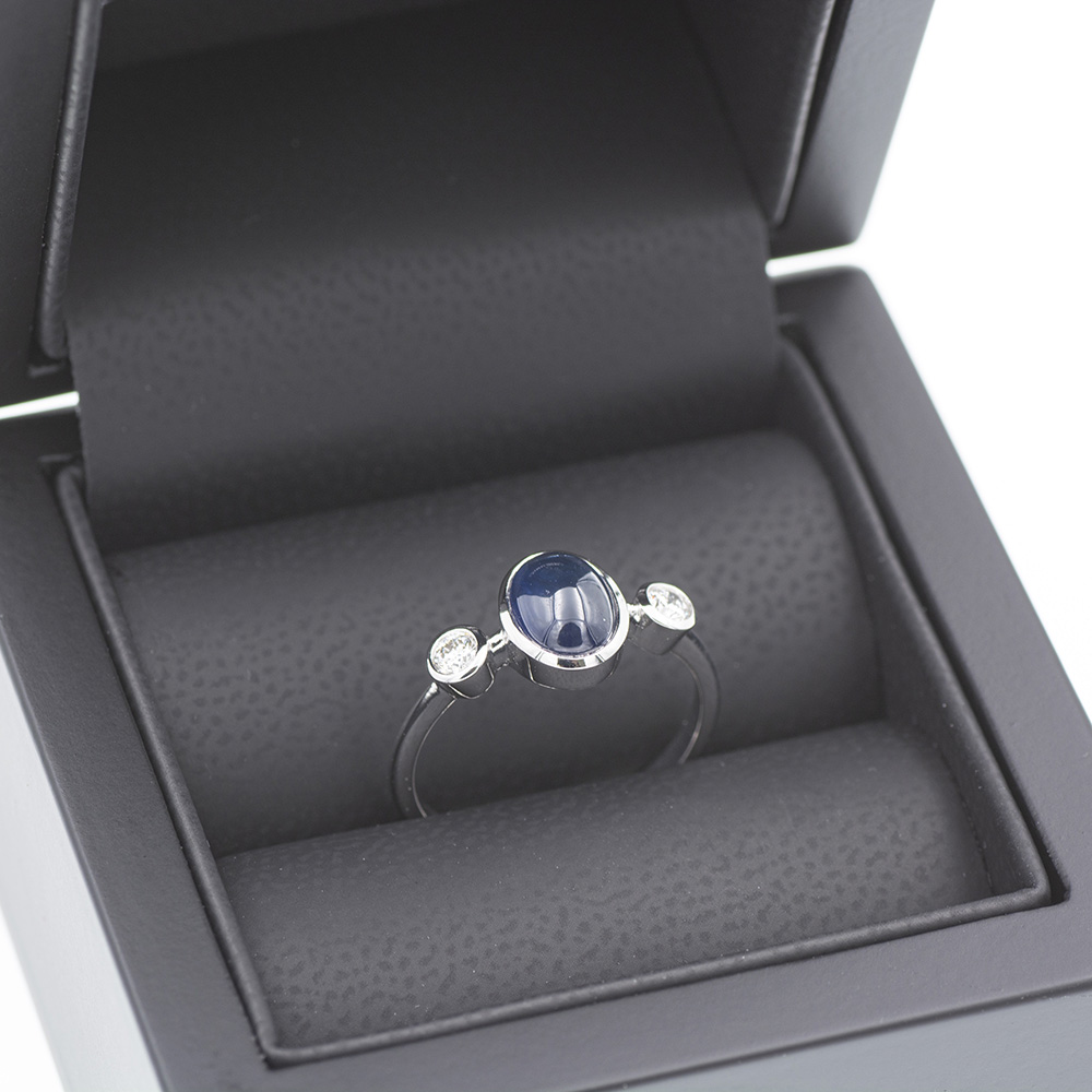 Anillo tresillo de oro blanco 750 con zafiro azul y diamantes.
